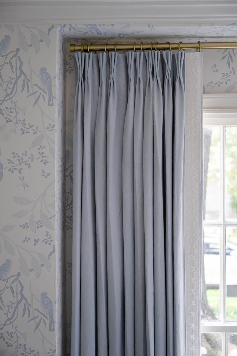 blue print interiors blue drapes brass curtain rod floral bird wallpaper